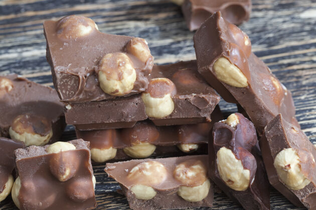 封面榛子和巧克力混合在甜巧克力中 由可可和可可脂与坚果制成糖果烹饪添加