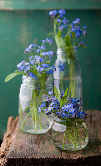 开花木桌上玻璃瓶里的花束背景新鲜小