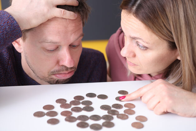 家庭一个男人和一个女人看着上面的硬币心烦意乱表.族预算规划概念支付经济投资