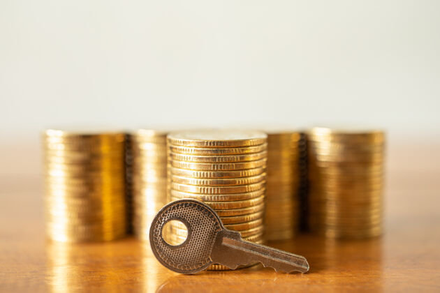 保险货币金融安全概念特写一把钥匙和一堆金币放在木桌上硬币货币市场