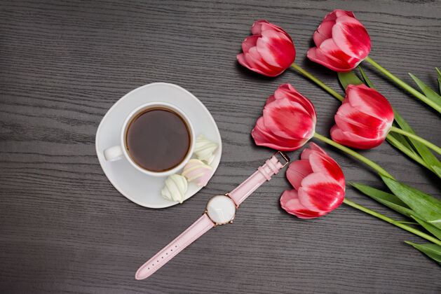 礼物一杯咖啡 棉花糖 手表和三个粉红色的郁金香.黑背景情人节杯子假日