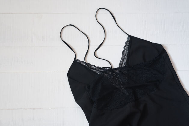 套装小黑裙的细节与蕾丝上的白色背景.服装概念上衣木制外观