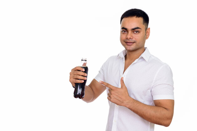 刷新年轻英俊的印度男人拿着一瓶苏打水指着手指饮料口渴口渴