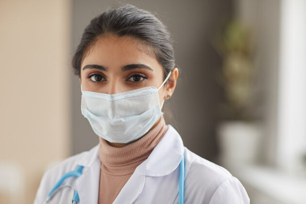外科医生戴着防护面罩的护士站在医院前面的特写镜头微笑护理正视图