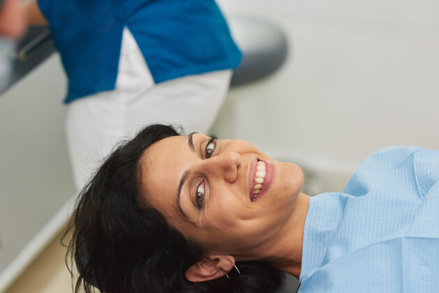 专业美丽的病人微笑着躺在牙科诊所的椅子上健康卫生牙科