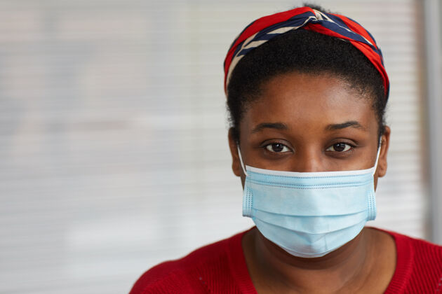 站立特写镜头：戴着防护面具的年轻女子看着前方 她在保护自己远离疾病卫生防护服严重