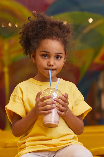美丽小女孩用吸管喝牛奶鸡尾酒的画像享受童年健康的生活方式