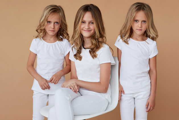 家庭前面的特写肖像三姐妹金发卷发穿着白色衣服快乐姐姐女孩