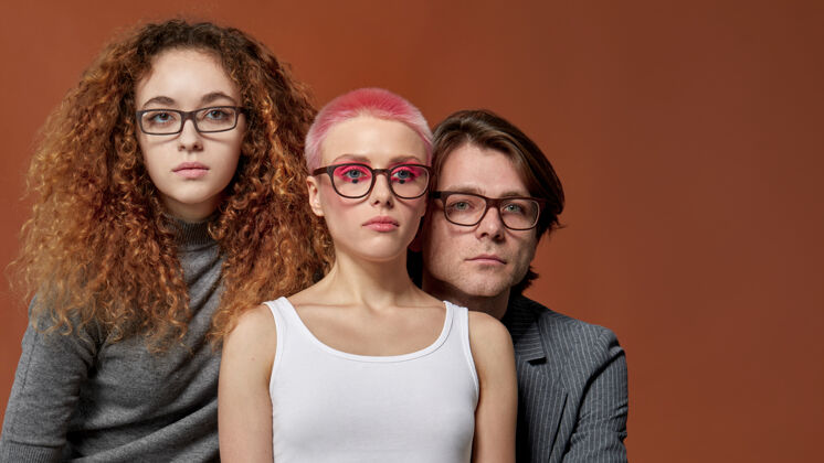 粉色头发正面肖像三位年轻的白种时尚模特穿着休闲服 戴着眼镜时尚男人发型