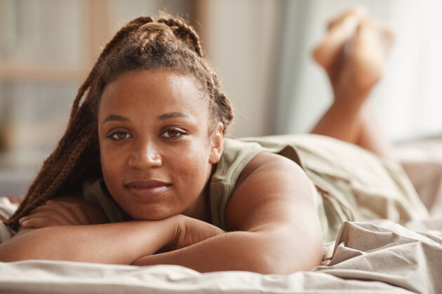 卧室早上躺在床上休息的非洲美女的画像休息棕色头发舒适