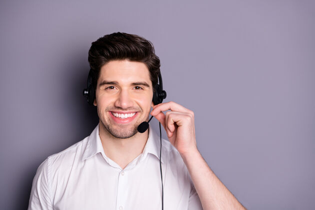 接待员聪明自信的呼叫中心工作人员的画像男士戴耳机可以帮助客户穿正式的衣服隔着灰色的墙领子支持耳机