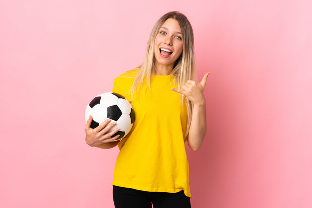 球一个年轻的足球运动员 一个孤立的女人 对着粉色的手机做手势电话运动员通话