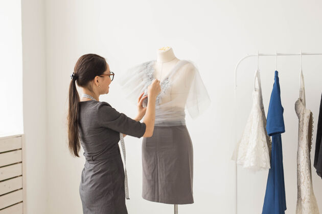 忙碌年轻的女时装设计师在工作垂直小裁缝