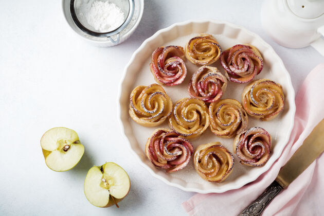 温暖美味的馅饼与一个苹果玫瑰在一个轻混凝土或石头表面陶瓷形式圆形芳香泡芙