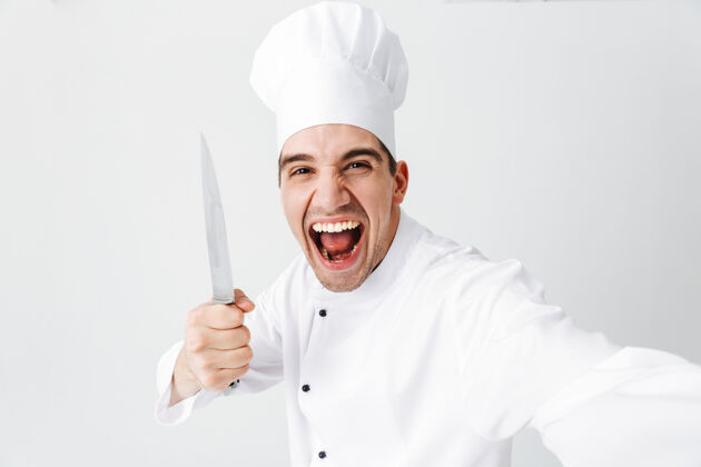 烹饪快乐厨师厨师穿着制服孤立地站在白色的墙上 自拍 拿着刀帅气服务人类