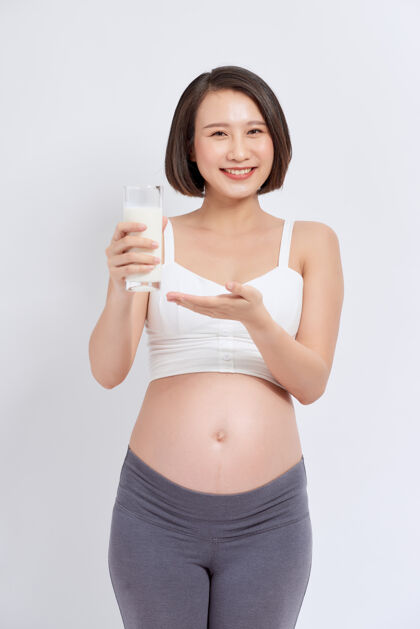产妇怀孕的女孩喝白色背景的牛奶牛奶微笑牛奶