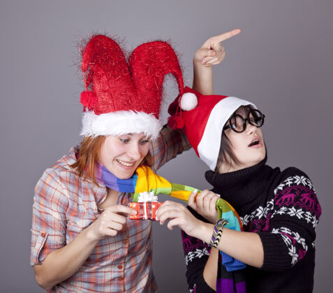 女性两个有趣的女孩过圣诞节礼品工作室射击女人帽子礼物