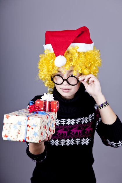 年轻戴着圣诞眼镜的滑稽女孩礼品工作室射击玩享受圣诞节