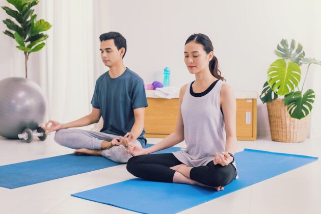 姿势亚洲年轻夫妇在家一起锻炼和练瑜伽冥想快乐训练