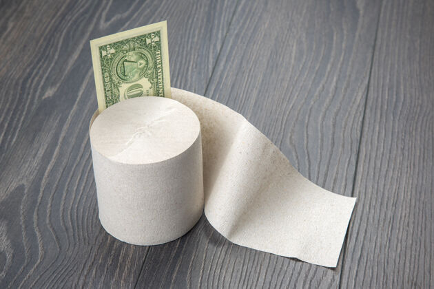 卫生木制背景上带美元钞票的卫生纸厕所卫生纸厕所