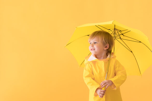 孩子穿雨衣的快乐孩子季节不寻常下雨