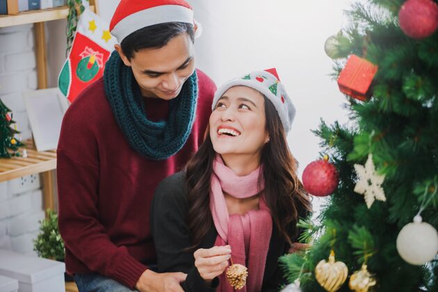 爱一对年轻的亚洲夫妇正在装饰圣诞树年轻微笑浪漫