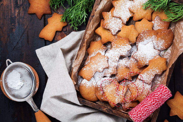 传统自制圣诞新年星型姜饼饼干放在旧木制复古表面的陶瓷盘子里配料庆祝粉末
