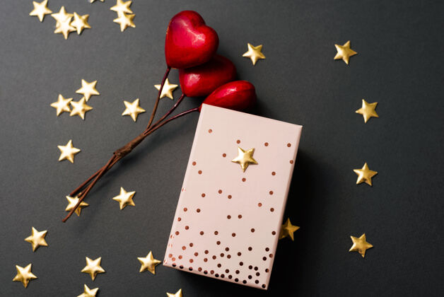 明亮一张可爱的照片 在一些星星和一些红色的心形装饰物附近 有一个包装好的礼物年球快乐