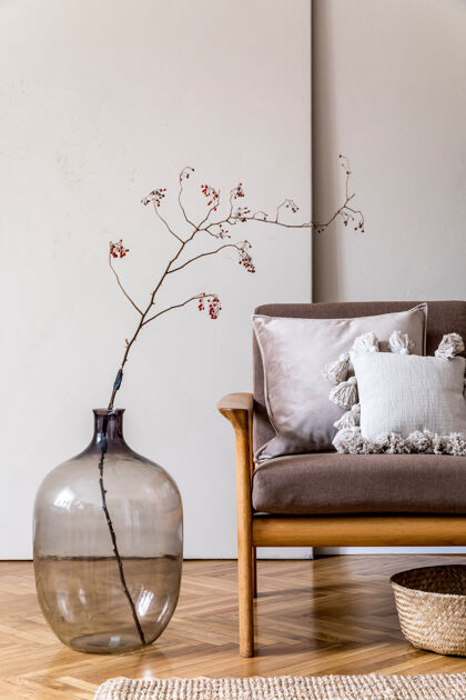 客厅客厅的现代室内设计有棕色木沙发 枕头 藤编篮子 玻璃花瓶 花卉和优雅的配饰米色和日式概念时尚的家居舞台沙发室内椅子