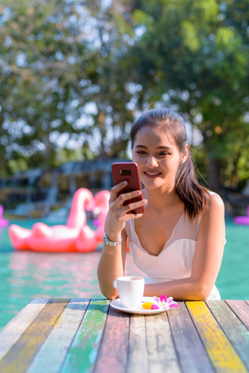 使用年轻美丽的亚洲女游客在湖边户外放松的画像公园船