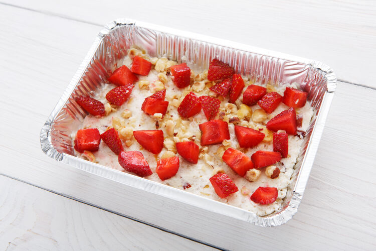 铝箔天然甜点用锡箔盒带走有机食物白木桌上有草莓和坚果的燕麦粥浆果有机健康