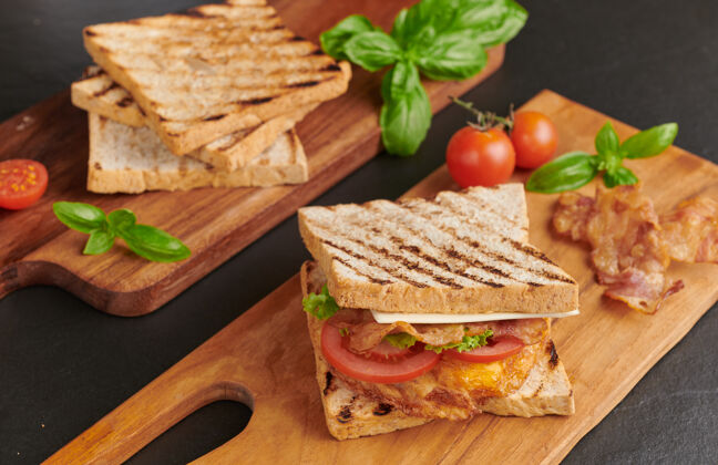 绿色烤制三明治 配培根 煎蛋 西红柿和生菜 放在木制砧板上食物美味面包