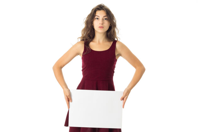 人可爱的黑发年轻女子身穿红色连衣裙 手拿白色标语牌圣诞节纸文件