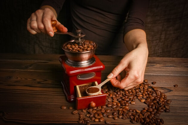 准备一个女人的手和咖啡研磨机机器成人新鲜