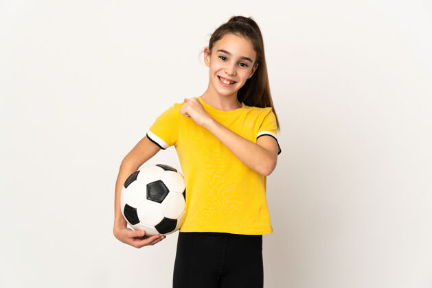 快乐一个足球运动员小女人孤零零地站在白墙上庆祝胜利童年专业足球