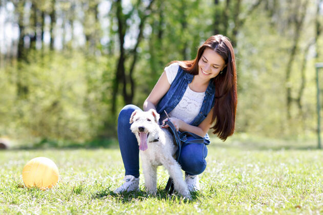 休闲美丽少女和她的狗的画像微笑朋友公园
