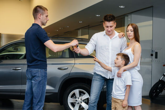 汽车一个快乐的年轻家庭在汽车经销店挑选并购买一辆新车新车购物购买
