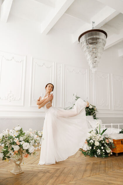 动作优雅的芭蕾舞演员在床旁的一个轻古典大厅跳舞白色年轻舞蹈