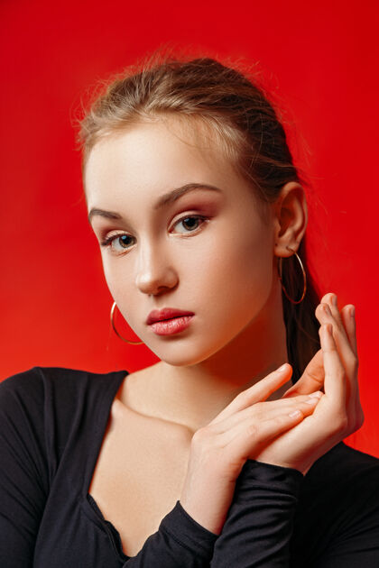 可爱年轻女子在红墙上摆姿势女人黑发模特