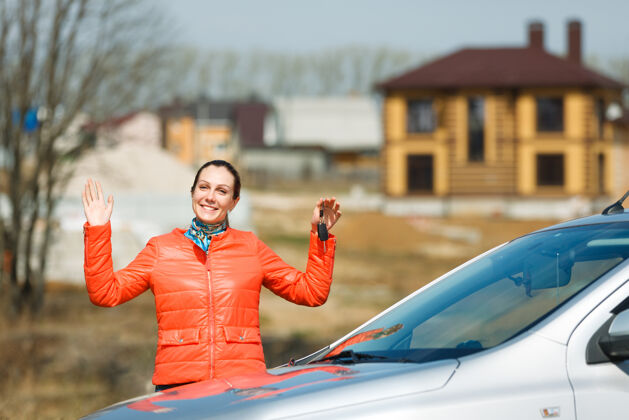 加油快乐的女人手里拿着车钥匙在家销售女人女性
