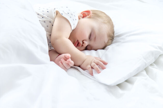 小宝宝睡在白色的床上婴儿人类室内