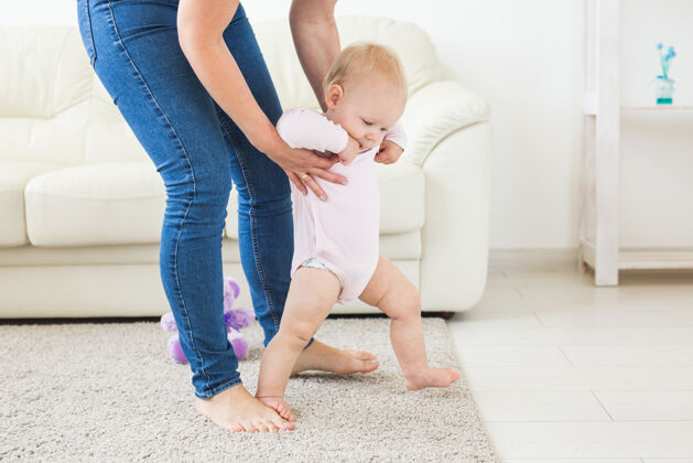 父母小女婴学走路的第一步第一可爱积极