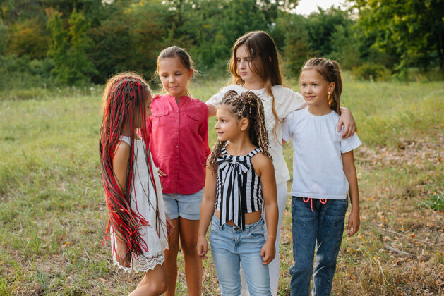 小学生日落时分 一群快乐的女孩在公园里微笑玩耍儿童夏令营日落娱乐肖像