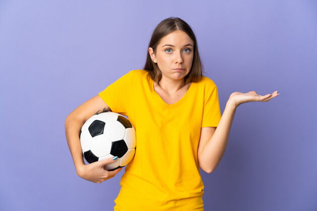 人立陶宛年轻的足球运动员 一个被孤立在紫色背景下的女人 举手时有疑虑比赛青年兴趣