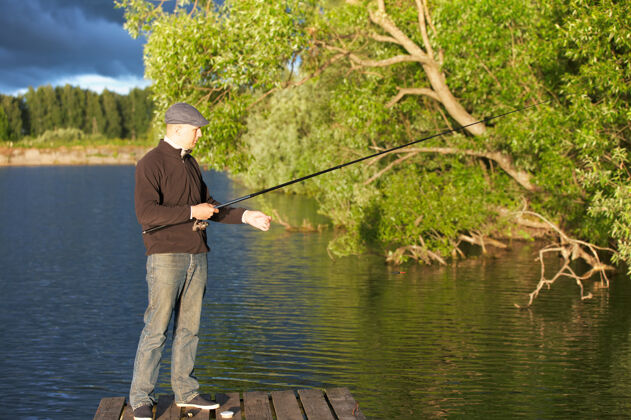 人在阳光明媚的日子里在池塘里钓鱼的人娱乐天湖