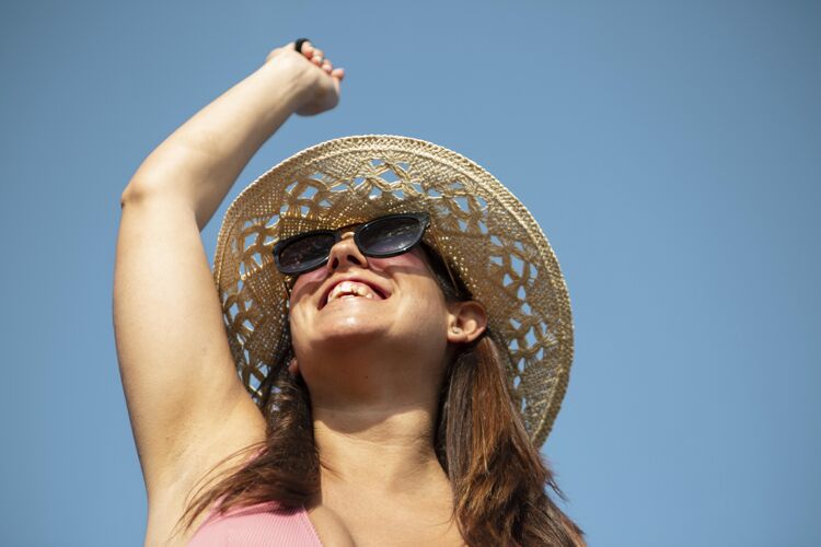 海边特写笑脸戴帽子的女人户外假日乐趣