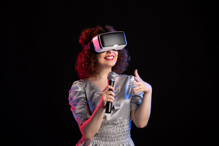 音乐家年轻女性戴着带麦克风的虚拟现实耳机音乐游戏技术视频美丽麦克风表演