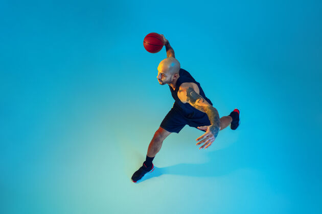 身体顶视图年轻的篮球队员穿着运动服训练 在运动中练习 在霓虹灯下蓝色背景下运动运动的概念 运动 活力和活力 健康的生活方式活跃健身篮球