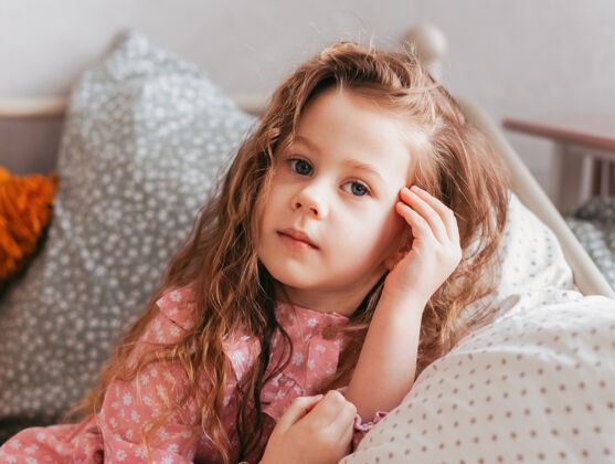 床一个小女孩躺在床上的枕头上卧室关闭-向上看肖像衣服肖像童年