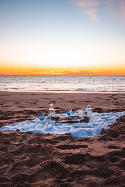 光日落天空下海边野餐的垂直镜头海洋海岸太阳